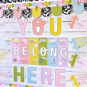 May include: A classroom bulletin board display featuring the text YOU BELONG HERE in large colorful letters. The center includes six locker-style panels decorated with stickers. Surrounding the center are pennants labeled with names.