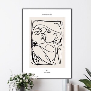 May include: Black and white line art print of two figures embracing. The print is on a beige background and has the text "ABSTRACT GALLERY" and "No. 1 THE LOVERS" at the top and bottom.
