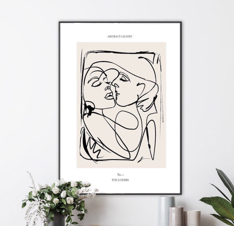 May include: Black and white line art print of two figures embracing. The print is on a beige background and has the text "ABSTRACT GALLERY" and "No. 1 THE LOVERS" at the top and bottom.