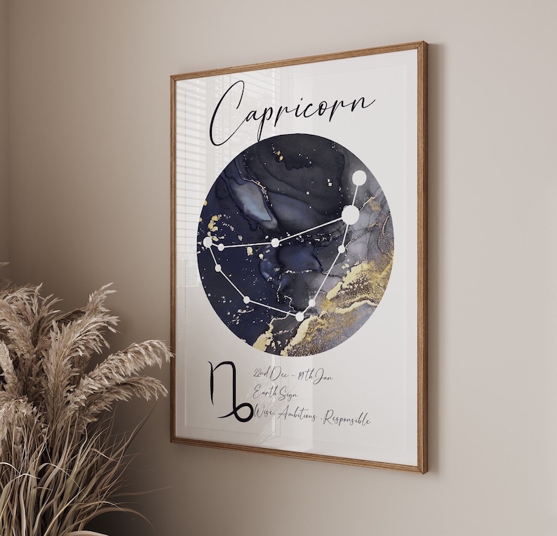 May include: A black and gold watercolor print with the Capricorn zodiac sign. The print features a constellation with a dark blue background and gold accents. The text "Capricorn" is written in black at the top of the print. The text "22nd Dec - 19th Jan", "Earth Sign", and "Wise, Ambitious, Responsible" is written in black at the bottom of the print.