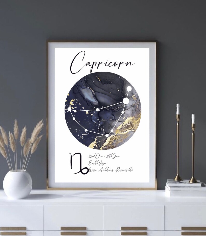May include: A white background with a black and gold watercolor circle featuring the constellation Capricorn. The text "Capricorn" is written in black cursive above the circle. Below the circle is the Capricorn symbol, the dates "Dec 22nd - Jan 19th", the text "Earth Sign", and the words "Wise, Ambitious, Responsible".