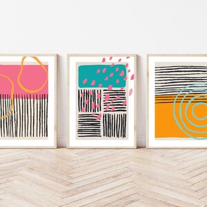 May include: Three abstract art prints with geometric shapes and patterns in black, white, pink, orange, yellow, and blue.