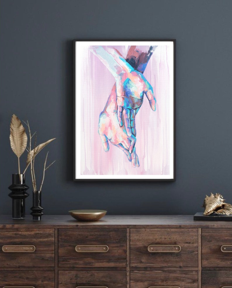 Puede incluir: Una pintura de dos manos entrelazadas, pintadas en tonos de rosa, azul y blanco sobre un fondo rosa.
