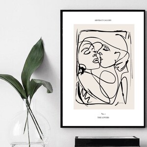 May include: Black and white line art print of two people embracing. The print has a beige background and the text "ABSTRACT GALLERY" and "No. 1 THE LOVERS" at the top and bottom.