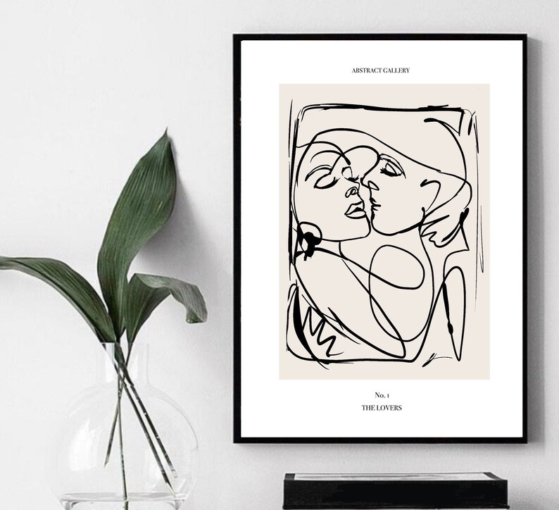 May include: Black and white line art print of two people embracing. The print has a beige background and the text "ABSTRACT GALLERY" and "No. 1 THE LOVERS" at the top and bottom.