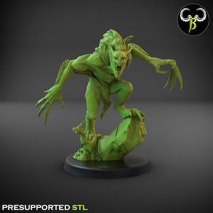 May include: A green 3D printed miniature of a monstrous creature with bat-like wings and sharp claws, standing on a rocky base. The creature has a snarling expression and is posed in a menacing stance. The miniature is pre-supported for easy printing.