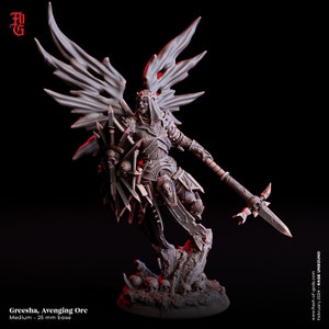 Puede incluir: Una figura miniatura gris y negra de un guerrero Orc con alas, sosteniendo una lanza y un escudo. La figura está de pie sobre una base con cráneos. El texto "Greesha, Avenging Orc" y "Medium - 25 mm base" es visible debajo de la figura.