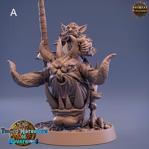 May include: A miniature figurine of a goblin riding a monstrous boar. The goblin is holding a spear and has a fierce expression on its face. The boar is detailed with tusks, horns, and a snarling mouth. The figurine is painted in a brown and grey color scheme. The text "The Tusked Marauders of Gauntwood" is visible on the base.