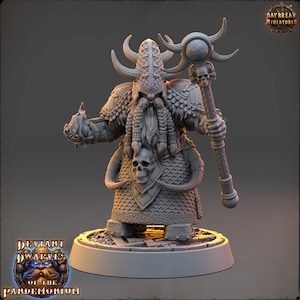 May include: A grey, detailed miniature of a dwarf wizard with a long beard, wearing a horned helmet and holding a staff with a skull at the top. The miniature is standing on a round base.