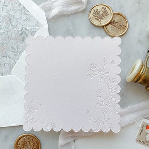 Juego de papelería con cinco tarjetas festoneadas y diseño floral impreso en tipografía.