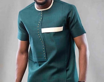 May include: A man wearing a teal short-sleeved shirt with a white trim and a white pocket. He is also wearing a brown hat and sunglasses. The shirt has gold accents and a slit on the side. The text "Learn to tailor this on YouTube Mr fii - bow and spear design" is at the bottom of the image.