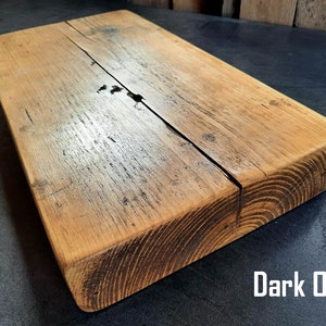 May include: A dark oak wood shelf with a rustic, distressed finish. The shelf is made of reclaimed wood and has a natural, uneven surface.