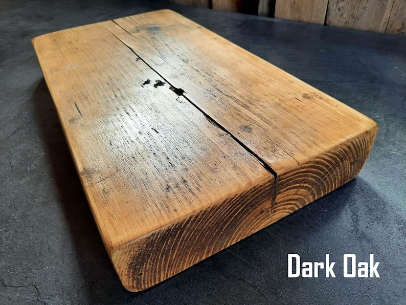 May include: A dark oak wood shelf with a rustic, distressed finish. The shelf is made of reclaimed wood and has a natural, uneven surface.