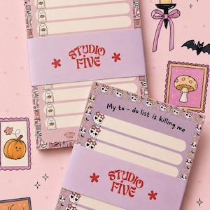 May include: Two rectangular paper notepads with a light purple band labeled Studio Five. One notepad features ghost icons and the text A little Boo-sy Today. The other notepad displays skull patterns and the text My to-do list is killing me.