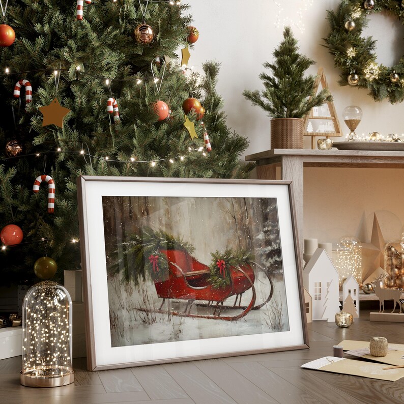 May include: A framed winter scene featuring a red sleigh laden with greenery and bows, set against a snowy forest backdrop. The image is part of a Christmas-themed display, with a decorated tree, ornaments, and festive decor.