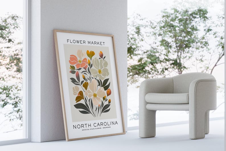 May include: A framed print with a floral design. The print features a bouquet of pink, white, and yellow flowers with green leaves. The text "FLOWER MARKET" and "NORTH CAROLINA" is printed at the top and bottom of the print.