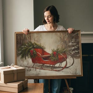 May include: A framed painting of a red sleigh decorated with evergreen boughs and red bows, set in a snowy forest scene. The artwork has a gold frame and evokes a winter holiday theme.