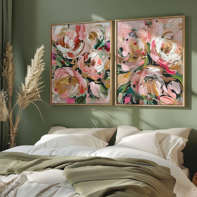 以下が含まれることがあります： 緑色の背景にピンク、白、金の花が描かれた、額縁に入った抽象的な花の絵画が2枚。絵画は、白い寝具と緑色の毛布を敷いたベッドの上に飾られています。