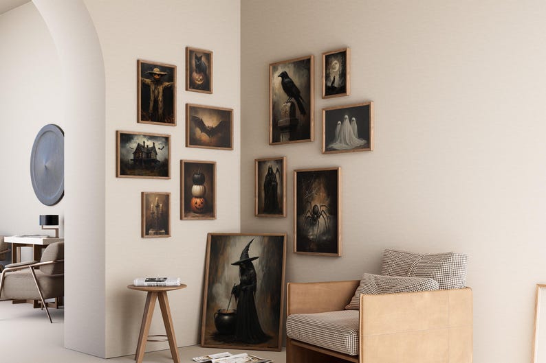 May include: A gallery wall with a variety of framed artwork featuring Halloween themes. The artwork includes images of a scarecrow, a crow, a witch, a cauldron, a haunted house, and ghosts. The artwork is displayed on a white wall with a light brown couch in the foreground.