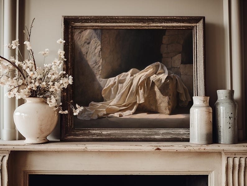 May include: A framed oil painting depicting a stone structure draped in white fabric, positioned between a white ceramic vase filled with white blossoms and two cylindrical ceramic vases in shades of cream and light gray.