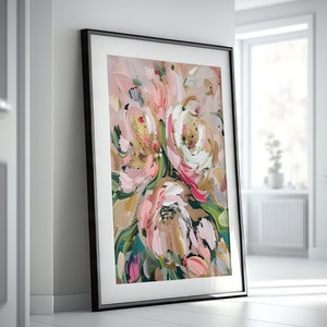 以下が含まれることがあります： ピンク、白、金色の花と緑の葉のブーケを描いた、額縁に入った抽象画。絵画は、筆触によるテクスチャ効果が施されています。