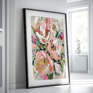 以下が含まれることがあります： 黒いフレームに入った抽象的な花の絵画。絵画はピンク、白、緑の花と金のアクセントが特徴です。
