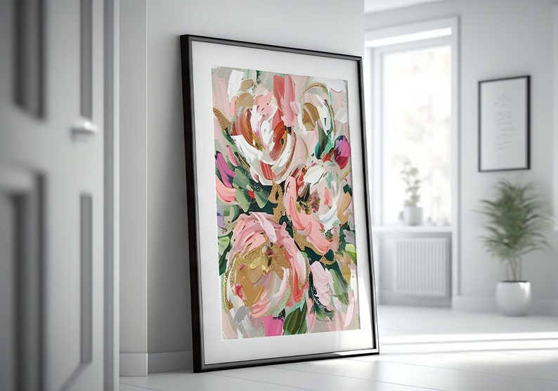 以下が含まれることがあります： 黒いフレームに入った抽象的な花の絵画。絵画はピンク、白、緑の花と金のアクセントが特徴です。