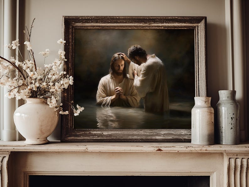 May include: A framed religious artwork depicts a baptism scene. Two figures in white robes stand in water, one with hands clasped in prayer. The artwork is displayed on a white mantelpiece, with a vase of white flowers and two ceramic jars.