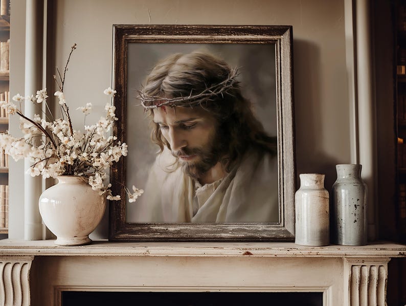 May include: A framed portrait of a man with long brown hair and a beard wearing a crown of thorns. The artwork is displayed on a mantelpiece next to a white vase filled with white flowers and two cylindrical ceramic containers.