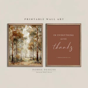 May include: Two framed wall art prints. The left print features a watercolor-style forest scene with tall trees in shades of brown, gold, and cream. The right print has a solid terracotta background with the white text: IN EVERYTHING GIVE thanks 1 THESSALONIANS 5:18.