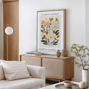 May include: A framed print with a floral design featuring a bouquet of pink, white, and yellow flowers with green leaves. The print has the text "FLOWER MARKET" and "NORTH CAROLINA OFFICIAL STATE FLOWER DOGWOOD" at the top and bottom.