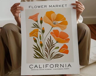 May include: A poster featuring the words "FLOWER MARKET" and "CALIFORNIA". The poster displays an illustration of orange California poppies with green leaves. The text "OFFICIAL STATE FLOWER - CALIFORNIA POPPY" is also present. The poster is held up by a person.