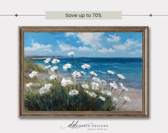 May include: A framed landscape painting depicts a coastal scene with white daisies in the foreground. The artwork features a blue sky with clouds, a turquoise ocean, and a sandy beach. The text "Save up to 70%" is visible at the top.