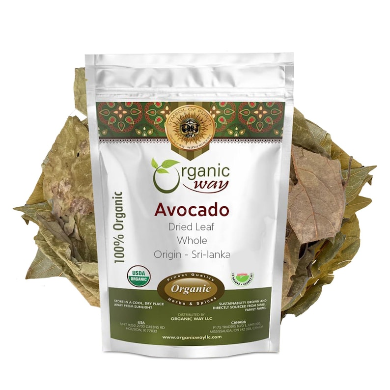 May include: A white resealable pouch with a silver foil exterior. The pouch contains dried avocado leaves. The front of the pouch has a label with the text "organic way" in a green circle, "Avocado" in a large font, "Dried Leaf Whole" in a smaller font, and "Origin - Sri-lanka" in a smaller font. The label also includes a USDA Organic seal and a "Finest Quality Organic Herbs & Spices" seal.