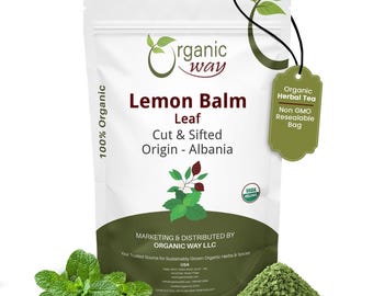 May include: A white packet of Organic Way Lemon Balm Leaf, cut and sifted, originating from Albania. The packet has a green and white design with the text "Organic Herbal Tea" and "Non GMO Resealable Bag" on a tag. A pile of green herbs and fresh leaves are in the foreground.