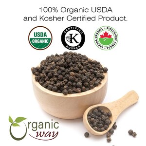 Puede incluir: Un bol de madera lleno de granos de pimienta negra. El bol est&aacute; sobre una superficie blanca. Tambi&eacute;n hay granos de pimienta esparcidos alrededor del bol. El bol est&aacute; al lado de una cuchara de madera llena de granos de pimienta. La imagen tambi&eacute;n incluye tres logotipos de certificaci&oacute;n: USDA Organic, Certified Kosher y Canada Organic.