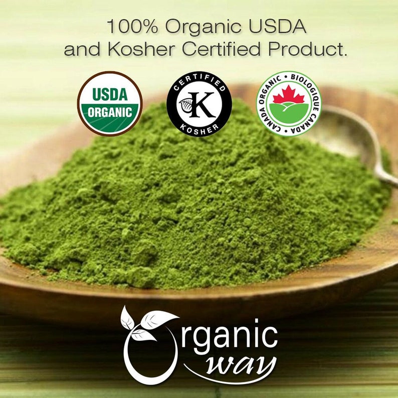 Peut inclure: Un gros plan sur un tas de poudre de matcha verte dans un bol en bois. La poudre est certifi&eacute;e USDA Organic, Kosher Certified et Organic Biologique Canada. Le texte "Organic Way" est visible en bas de l'image.