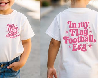 Puede incluir: Una camiseta blanca con texto rosa. La parte delantera dice "Yes, I Play like a Girl. Try to keep up!" y la trasera dice "In my Flag Football Era". La camiseta la lleva un niño con pantalones cortos vaqueros, gafas de sol rosas y un lazo rosa.