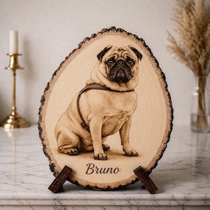 May include: A wooden plaque featuring a detailed portrait of a pug dog, complete with a harness. The dog's name, "Bruno," is engraved at the bottom. The plaque is oval-shaped with a natural bark edge and is supported by a wooden stand.