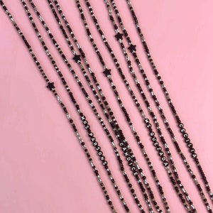 May include: Five black and white beaded lanyards with gold clasps and star charms. The lanyards have the names "Candice", "Msquezada", "Mrs Parsons", and "Cecilia" spelled out in black beads.