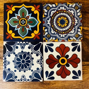 May include: Four square ceramic tiles with intricate blue, yellow, red, and white floral patterns. The tiles are arranged in a 2x2 grid.