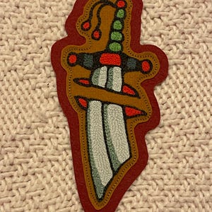 Kedjesömsbroderad dolklapp