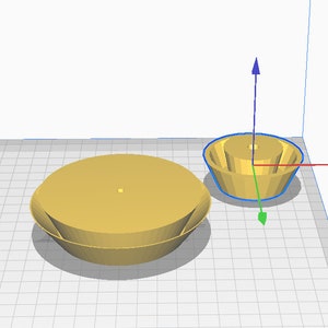May include: Two gold-colored, 3D-modeled objects. One is a large, shallow bowl shape with a flat top. The other is a smaller, inverted bowl shape with a cylindrical top. Both have a smooth, matte finish.