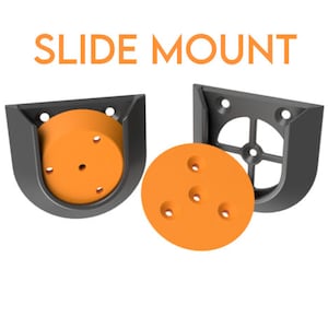 May include: Two black plastic slide mounts with orange plastic inserts. The mounts are designed to hold a round object in place. The text "SLIDE MOUNT" is printed in white on a white background.