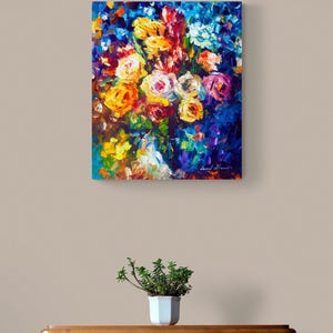 May include: An oil painting of a vibrant bouquet of flowers in shades of yellow, orange, pink, and blue. The artwork is displayed on a wall above a wooden dresser with a small potted plant.