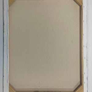 May include: Rear view of a stretched canvas artwork. The canvas is a pale beige, mounted on a wooden frame. The frame is visible, with white canvas stapled to the wood. The edges of the frame are painted black.