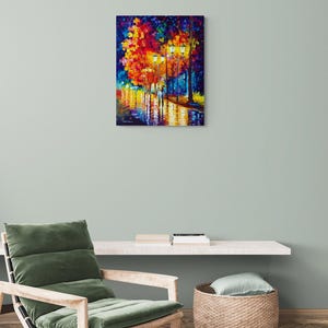 Peut inclure: Peinture &agrave; l'huile sur toile repr&eacute;sentant une sc&egrave;ne de rue nocturne. L'&oelig;uvre montre un couple marchant sur une rue mouill&eacute;e, &eacute;clair&eacute;e par des lampadaires et des arbres color&eacute;s. Le tableau est accroch&eacute; au mur au-dessus d'un fauteuil.