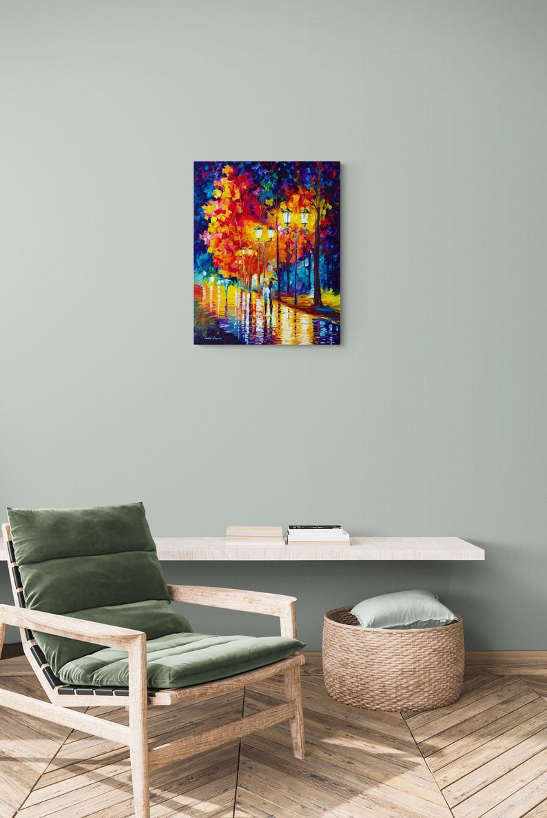 Peut inclure: Peinture &agrave; l'huile sur toile repr&eacute;sentant une sc&egrave;ne de rue nocturne. L'&oelig;uvre montre un couple marchant sur une rue mouill&eacute;e, &eacute;clair&eacute;e par des lampadaires et des arbres color&eacute;s. Le tableau est accroch&eacute; au mur au-dessus d'un fauteuil.
