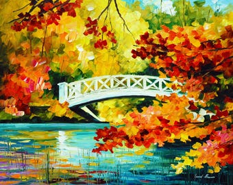 May include: An impressionistic painting of an autumn landscape. A white bridge arches over a body of water, surrounded by trees with vibrant red, orange, and yellow foliage. The water reflects the colorful scene, creating a sense of depth and tranquility.