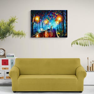 May include: A colorful oil painting depicts a romantic park scene at night. The artwork features a couple walking on a wet path, illuminated by streetlights. The painting is mounted above a yellow sofa, creating a cozy atmosphere.